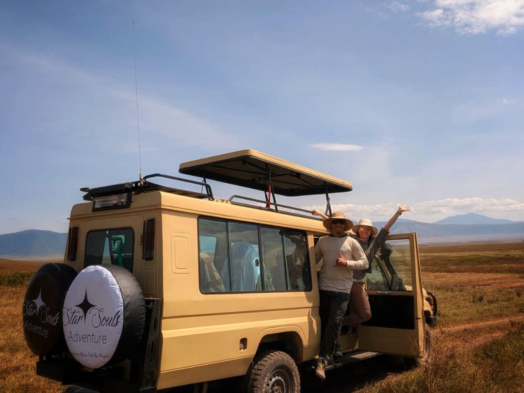 Star Souls guests celebrating beside their safari vehicle on the floor of the Ngorongoro Crater
